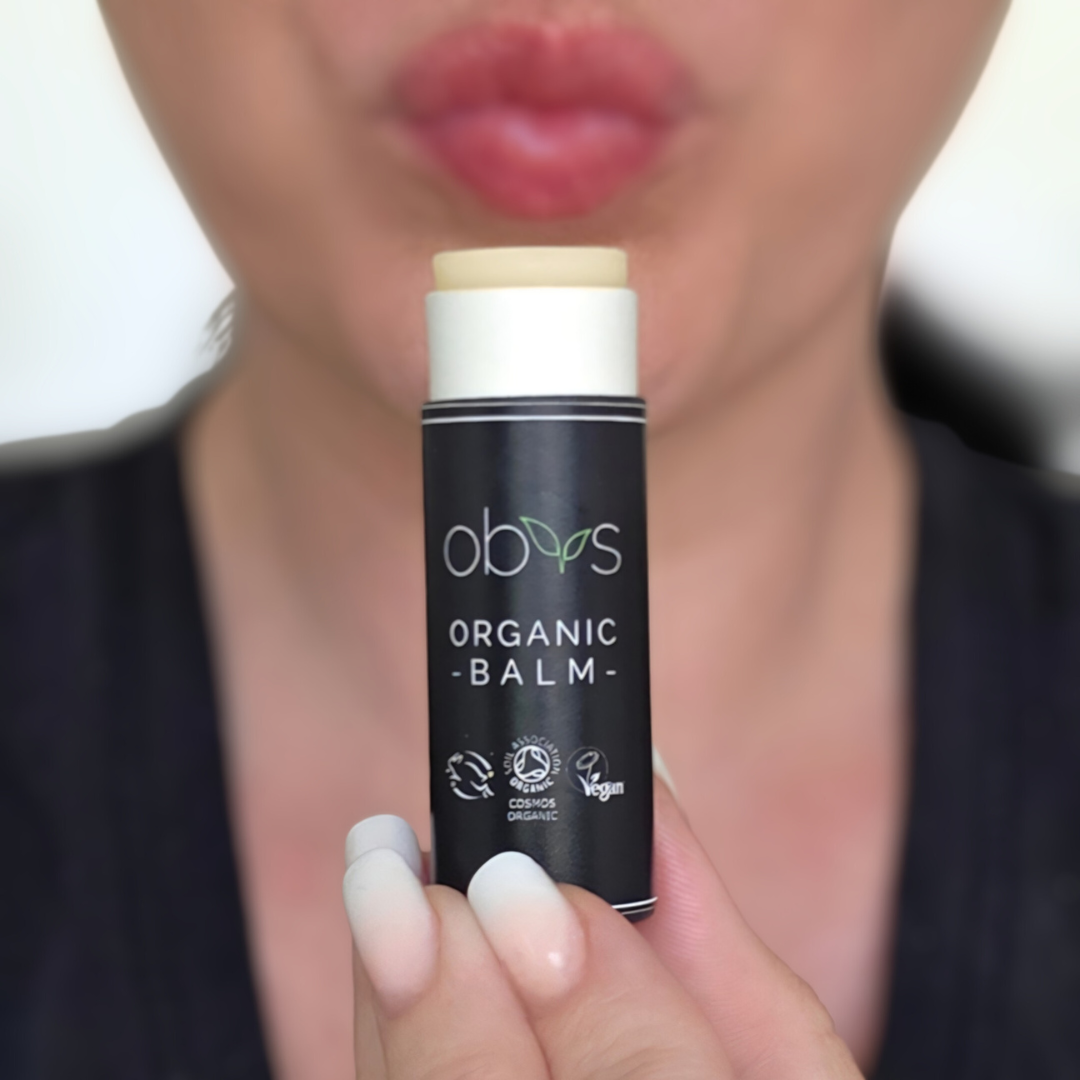 Person holding an organic balm stick with 'obvs' branding