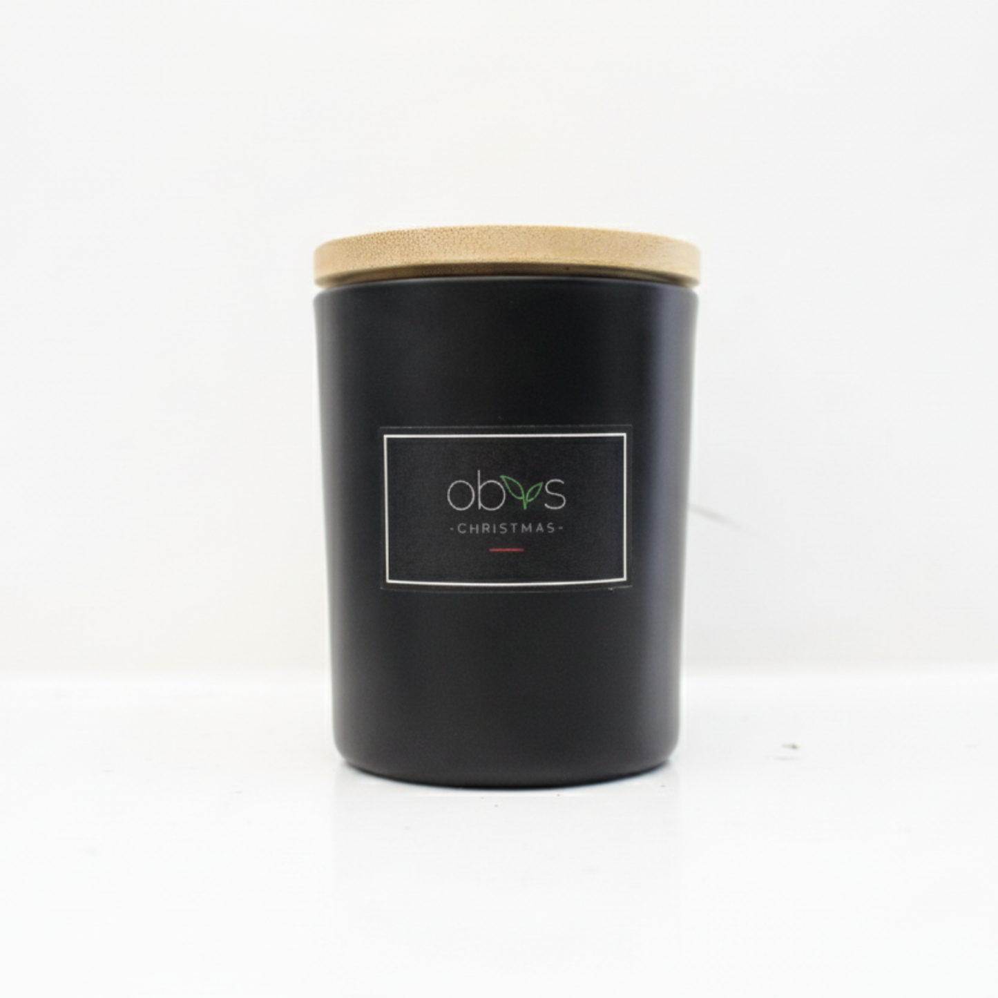 Black candle with a wooden lid on a white background Christmas candle with cinnamon, clove and ginger essential oils in a glass jar, hand-poured with coconut and rapeseed wax, cosy festive scent by Obvs Skincare