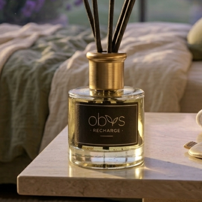 A bottle of Obvs recharge diffuser on a table with a blurred background