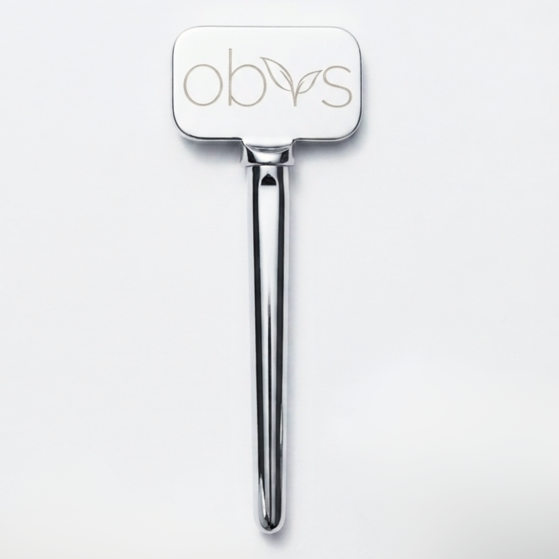 A polished silver metal hair tool with a rectangular head engraved with the brand name 'obvs' and a small leaf motif, shown on a clean white background.