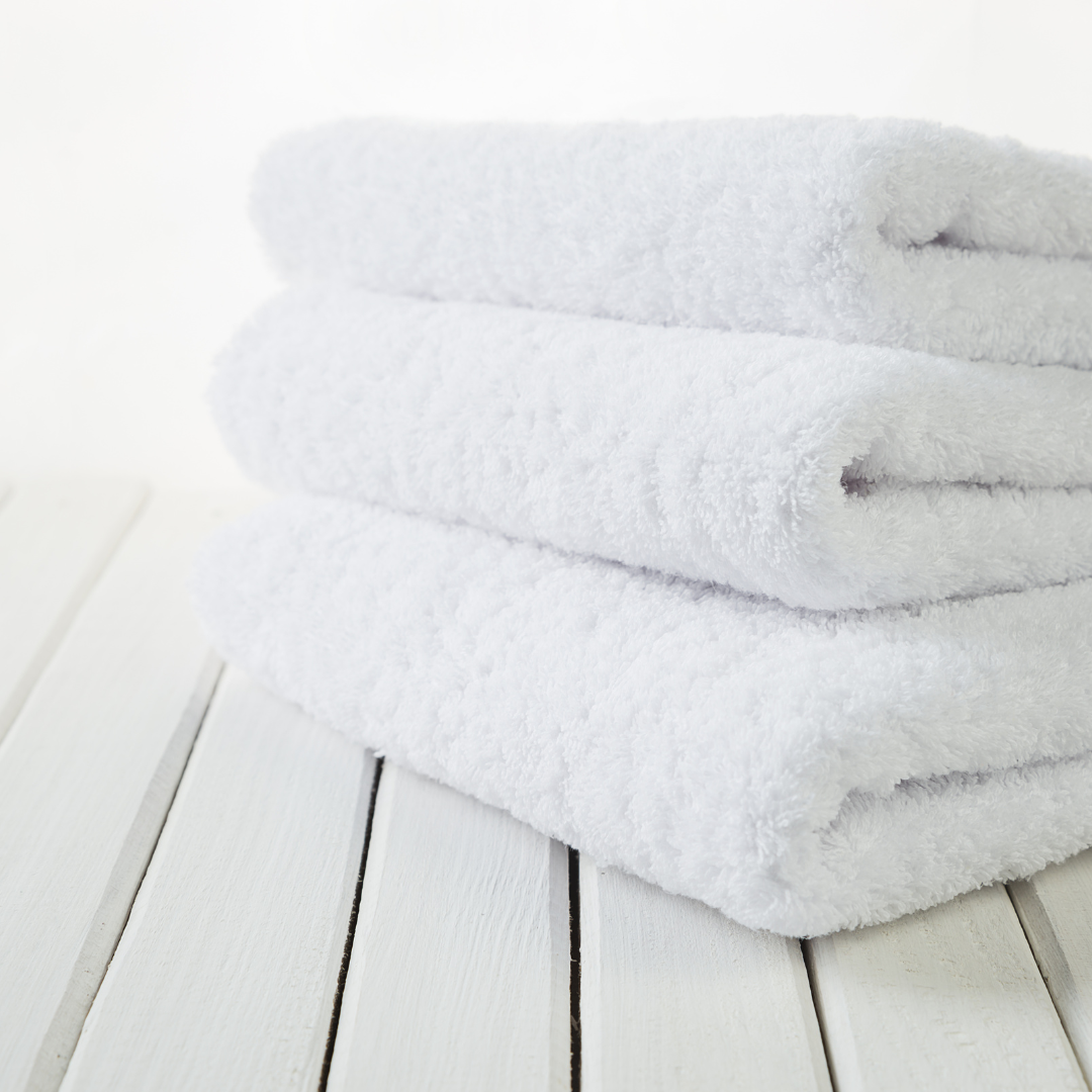 
A neatly folded organic cotton towel in a soft, natural shade, with a smooth, plush texture. The towel lies on a wooden surface, radiating a sense of warmth and luxury. Nearby, a hint of greenery adds a touch of nature, highlighting the towel’s eco-friendly, sustainable origins, perfect for a relaxing, spa-like self-care experience