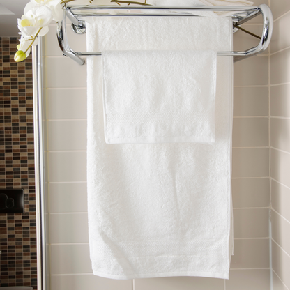 
A neatly folded organic cotton towel in a soft, natural shade, with a smooth, plush texture. The towel lies on a wooden surface, radiating a sense of warmth and luxury. Nearby, a hint of greenery adds a touch of nature, highlighting the towel’s eco-friendly, sustainable origins, perfect for a relaxing, spa-like self-care experience