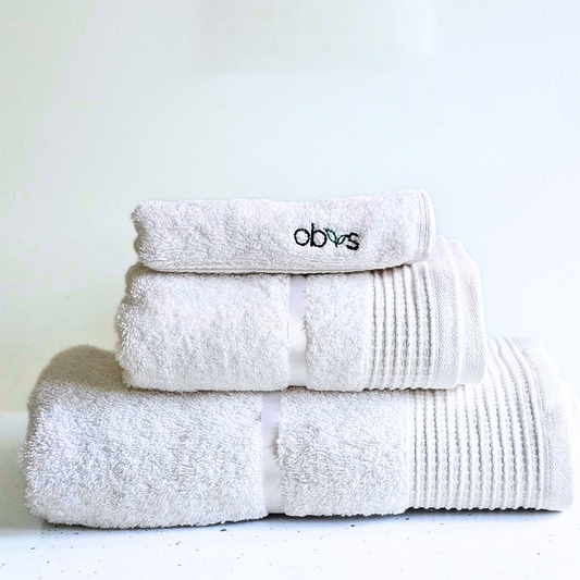 Indulge in the ultimate luxury with the Obvs at Home GOTS Certified Organic Towel Bundle. Crafted from the softest organic cotton, this collection—featuring a bath towel, hand towel, and Obvs face cloth—wraps you in pure, soothing comfort. The plush texture caresses your skin, elevating your daily ritual to an experience of serene indulgence. Eco-friendly and exquisitely soft, these towels are a true testament to sustainable luxury. Perfect for those who seek both indulgence and mindfulness in every moment.