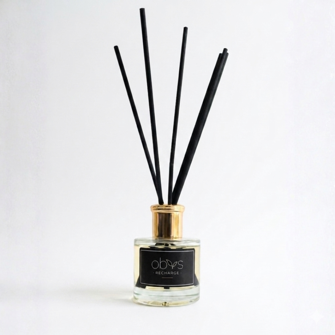 Reed diffuser with black sticks in a glass bottle on a white background