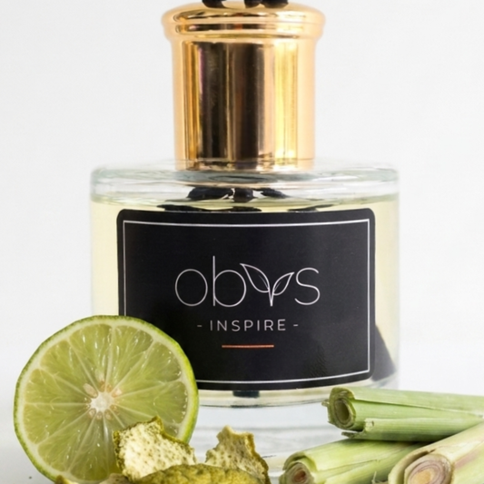 Perfume bottle labeled 'obvs' with a black label featuring the word 'Inspire', surrounded by lime slices and green leaves on a white background.
