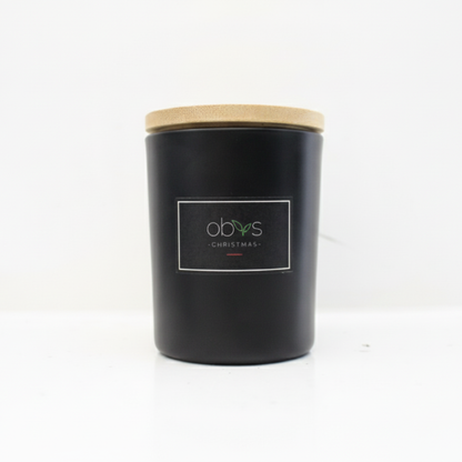 Black candle with a wooden lid on a white background Christmas candle with cinnamon, clove and ginger essential oils in a glass jar, hand-poured with coconut and rapeseed wax, cosy festive scent by Obvs Skincare